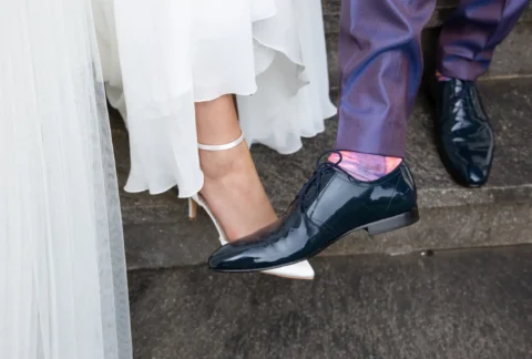 Braut und Bräutigam in eleganten Schuhen, Brautschuh in Weiß, Bräutigamschuhe in Schwarz, Treppe hinauf.